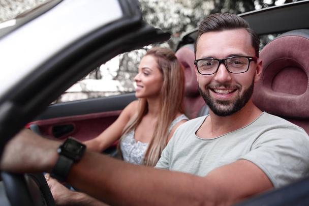 close up.stylish man with his girlfriend traveling in a convertible car. - Foto, Bild