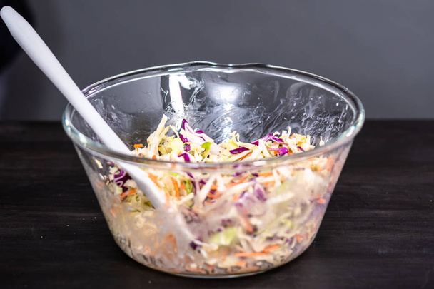 Hacer ensalada de col casera en un tazón de vidrio
. - Foto, Imagen