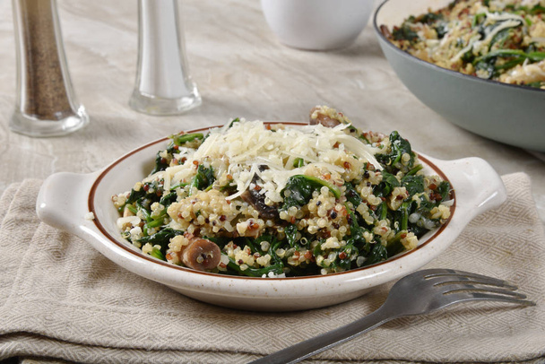 Bowl of hot spinach quinoa salad with mushrooms and parmesan cheese - Photo, image