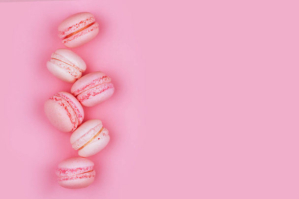 Group of sweet pink and white mini macarons on soft pink paper - Foto, afbeelding