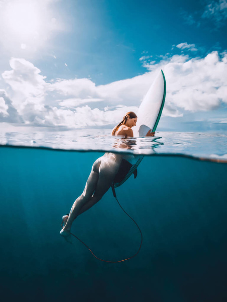 Naked surf girl with surfboard in blue ocean. Freedom and surfing - Photo, Image