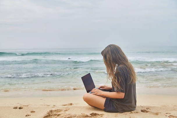 Sahilde bilgisayarda çalışan genç kız. Sahilde çalışma serbest meslek. Hint Okyanusu'nun Beach. Sri-lanka. - Fotoğraf, Görsel