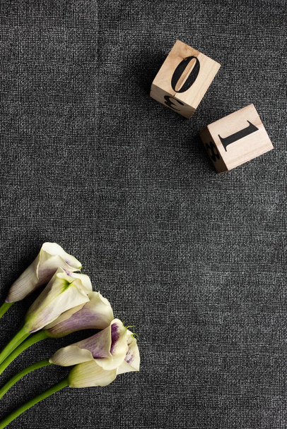 Αντικείμενο γυρίσματα από μια ανθοδέσμη λουλουδιών και ξύλινων κύβων με αριθμούς. Η εικόνα του θέματος. - Φωτογραφία, εικόνα
