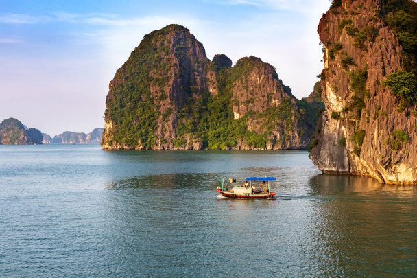 Barca da pesca tradizionale vietnamita nella baia di Halong al tramonto, patrimonio naturale mondiale dell'UNESCO, Vietnam
. - Foto, immagini