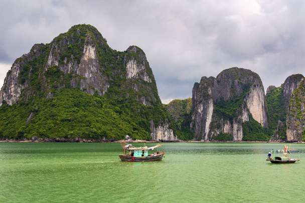 Halong bay kalkrotsen met twee Vietnamese traditionele vissersboten, Unesco werelderfgoed, Vietnam. - Foto, afbeelding