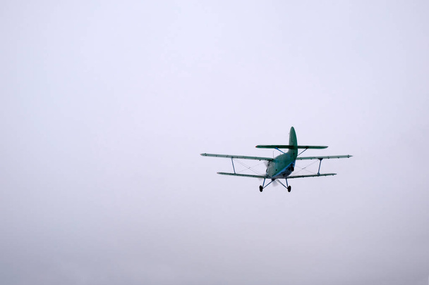 Χειμερινή σεζόν. Ένα πράσινο διπλάνο έχει μόλις απογειωθεί. - Φωτογραφία, εικόνα