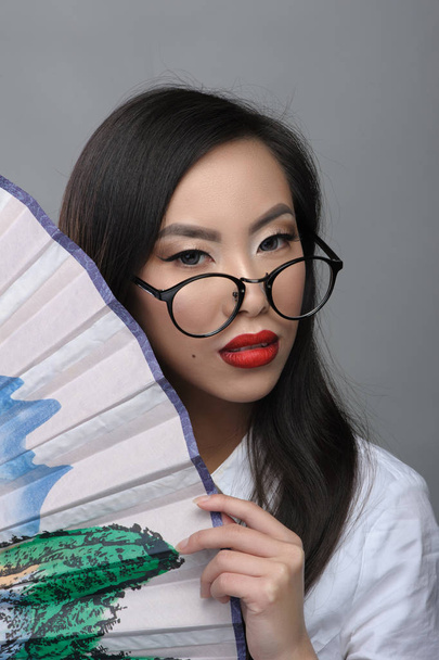 Portrét krásné asijské dívky s brýlemi v bílé halence - Fotografie, Obrázek