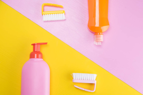 bottles with cleaning liquids on two-color background, pink and yellow - Foto, Imagem