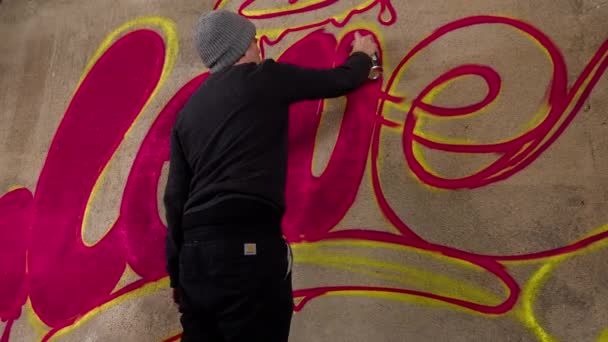 Διαδικασία του καλλιτέχνη γκράφιτι ψεκασμού λέξη αγάπη στο τσιμεντένιο τοίχο - Πλάνα, βίντεο
