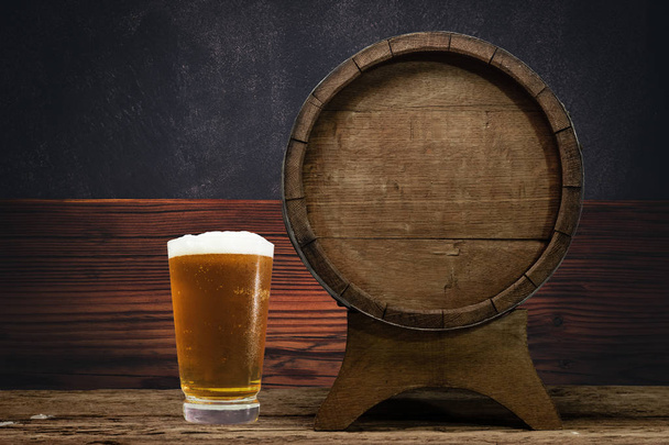 Drewniane beczki i szklankę piwa na stary dębowy stół z drewna. - Zdjęcie, obraz