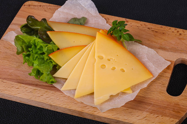 Fette di formaggio giallo svizzero affettato servito foglie di insalata - Foto, immagini