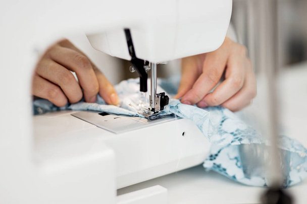 A woman is sewing with the electric sewing-machine. Fashion, tailors workshop. - Zdjęcie, obraz