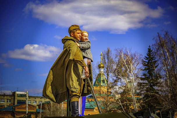 Overwinning vakantiedag 9 mei. Een soldaat met een kind in zijn armen symboliseert vrede, geluk en vreugde. Wie ons zal komen met een zwaard door het zwaard zullen sterven door. - Foto, afbeelding