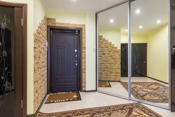 Просторий передпокій в квартирі з вбудованою шафою і величезними дзеркалами
 - Фото, зображення