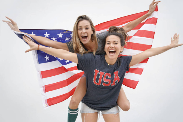 Energetic young friends proudly flying American flag on white background - Fotó, kép