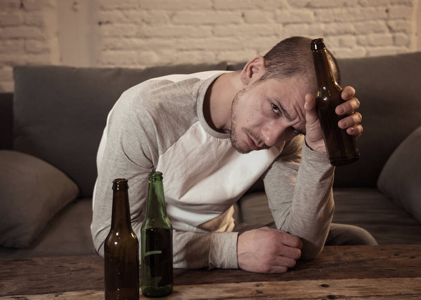 Young sad drunk men drinking beer and alcohol feeling wasted, lonely and desperate in pain and emotional stress. People and Alcohol abuse, addiction and man depression concept. Dramatic light - Foto, Imagem