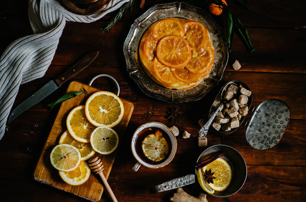 Sweet pie with orange caramelized slices on wooden background, top view - Fotó, kép