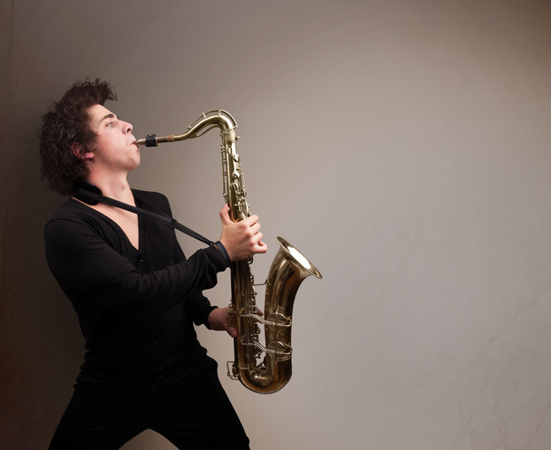 Young musician playing on saxophone - Photo, image