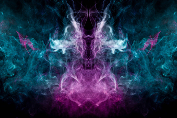 Толстый красочный дым голубого и розового цвета в виде черепа, монстра, дракона на черном изолированном фоне. Фон из дыма от паров. Мокап для крутой футболки
 - Фото, изображение
