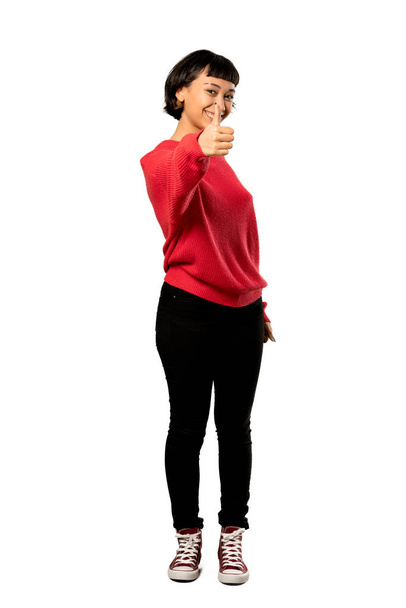 Ένα ολόσωμο πλάνο του μια σύντομη μαλλιά κορίτσι με το κόκκινο πουλόβερ με Μπράβο γιατί κάτι καλό έχει συμβεί πάνω από απομονωμένες λευκό φόντο - Φωτογραφία, εικόνα