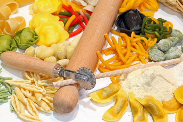 Pastas caseras italianas con utensilios de cocina y un raviolo con tinta de sepia
 - Foto, imagen