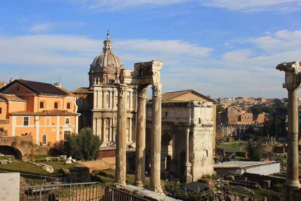 Ruínas do Fórum Romano. Templo de Vespasiano e Tito, Arco de Sétimo Severo e igreja de Santi Luca e Martina em Roma. Itália
 - Foto, Imagem