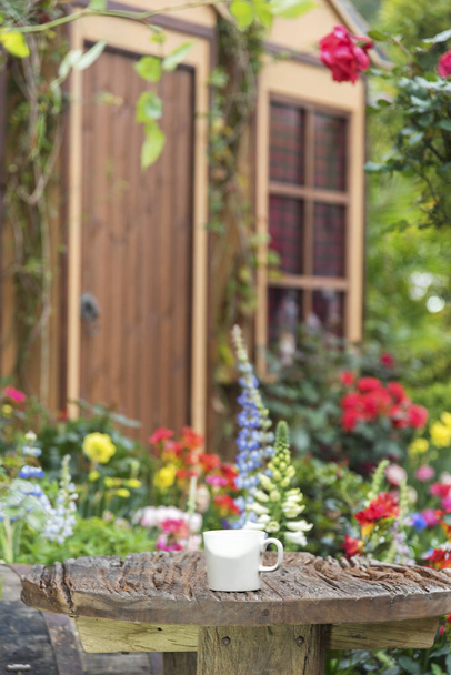 Xícara de café e mesa no jardim do quintal da casa residencial
 - Foto, Imagem