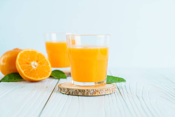 Fresh orange juice on wood background - healthy drink - Fotó, kép