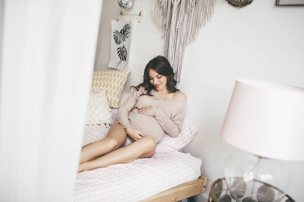 Beautiful young pregnant woman at home lying in bed - Foto, Bild