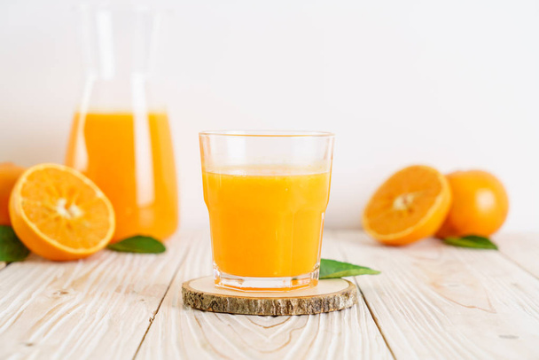 Fresh orange juice on wood background - healthy drink - Zdjęcie, obraz
