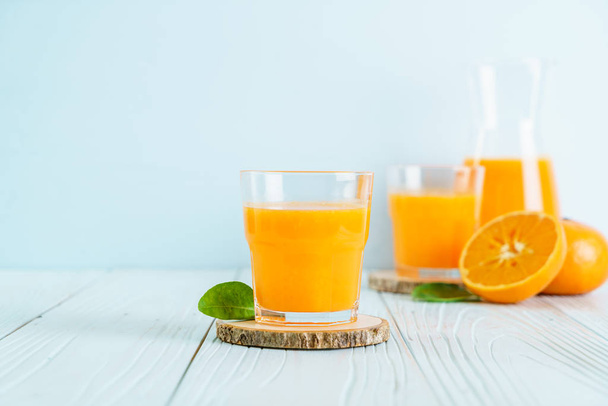 Fresh orange juice on wood background - healthy drink - Foto, afbeelding