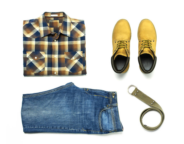 Flat lay set Men's casual clothing, blue jeans, checkered shirt, yellow nubuck shoes, strap isolated items on white background top view with space for text. Male fashion, clothes for rest, travel - Photo, Image