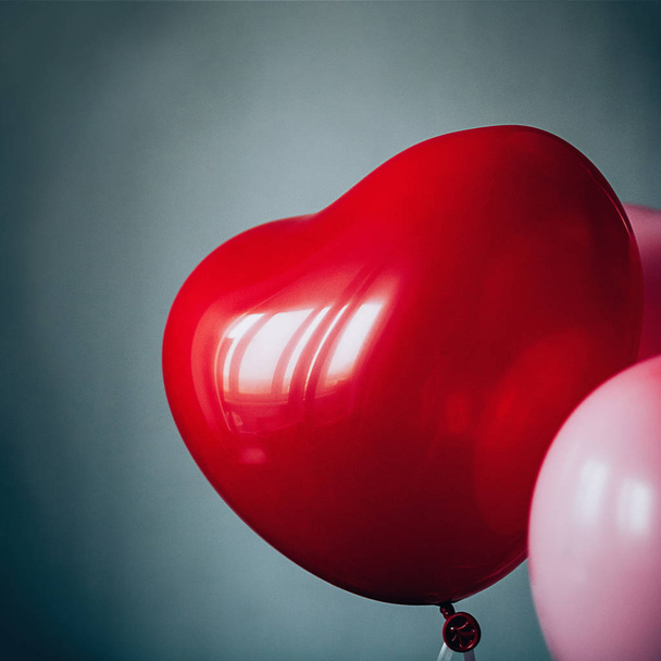 Sweet love Valentines romantic concept. Vintage red pink balloons heart shape flying up against pastel blue backdrop. Film grain effect, Soft selective focus square image - Foto, Imagen