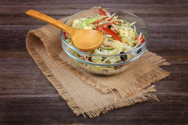 Fresh vegetables and vegetable salad in dishes on wooden background. - Foto, Imagem