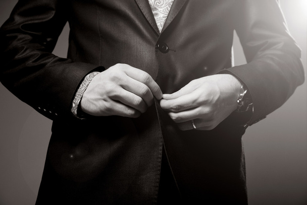 ο άνθρωπος των επιχειρήσεων συγυρίζουν κουμπί κοστούμι του, κάνει μια τακτοποιημένη εικόνα - Φωτογραφία, εικόνα