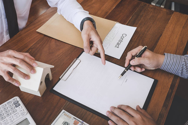 Business Signing a Contract Buy - sell house, Man sign a home insurance policy on home loans, insurance agent analyzing about home investment loan Real Estate concept. - Fotoğraf, Görsel