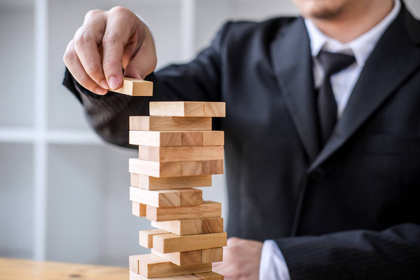 Alternative risk concept, plan and strategy in business, Risk To Make Business Growth Concept With Wooden Blocks, Images of hand of business people placing and pulling wood block on the tower. - Φωτογραφία, εικόνα