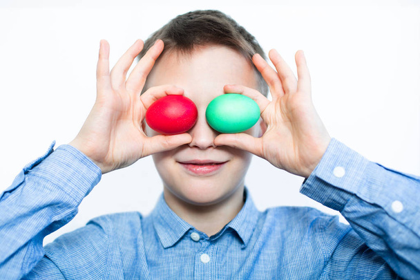 Cheerful the boy is holding a red and green egg. Easter eggs. Preparation for the holiday. Easter. Closeup - Foto, Bild