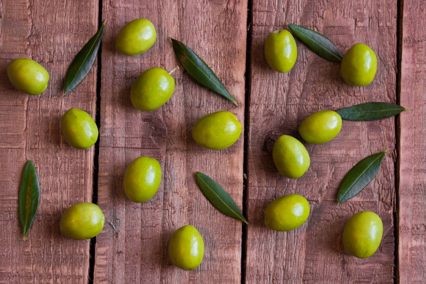 frische grüne Oliven auf dunklem Waldhintergrund - Foto, Bild