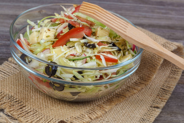 Fresh vegetables and vegetable salad in dishes on wooden background. - Fotó, kép