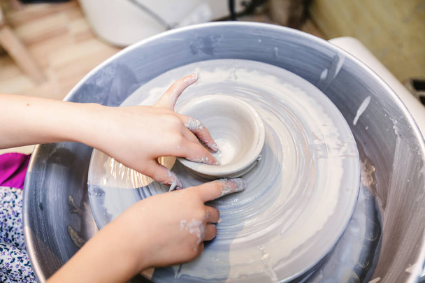 Mãos criativas para crianças - Fazer artes - Moldar argila na roda de cerâmica - Oficina de criatividade
. - Foto, Imagem