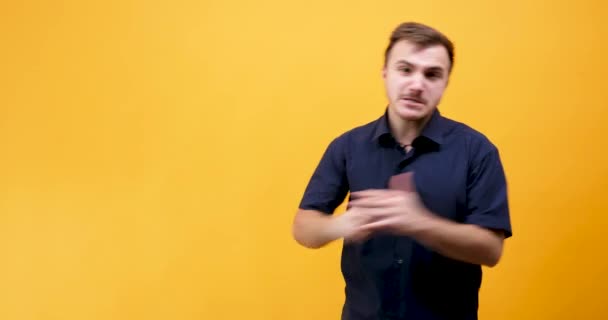 Rozzlobený kavkazské mladý muž chce bojovat proti někomu agresivně izolované na žluté oranžové pozadí - Záběry, video