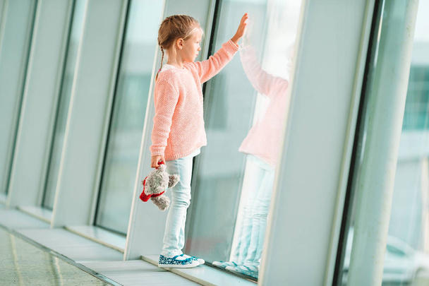 Adorable little girl in airport with her luggage waiting for boarding - Valokuva, kuva