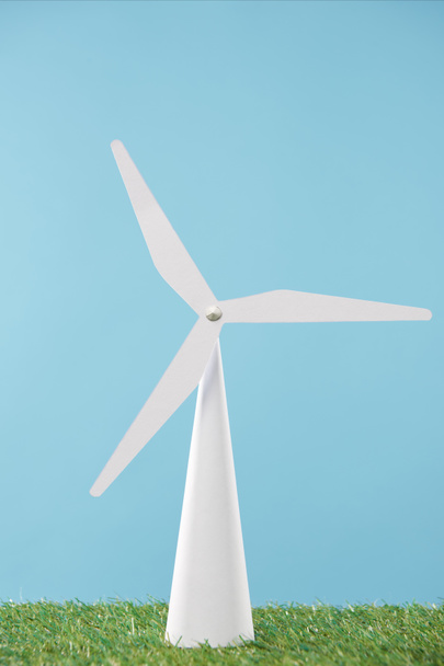 modelo de molino de viento blanco sobre hierba verde y fondo azul
 - Foto, imagen