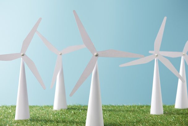 modelos de moinho de vento branco no fundo azul e grama verde
   - Foto, Imagem