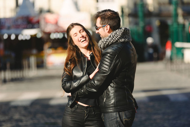 Couple in love embraced in an urban scene, with unfocused background and copy space. - Photo, Image