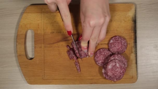 Slicing sausage on a cutting board. Beef sausage. Cut with a kitchen knife. - Footage, Video