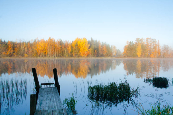 Beautiful autumn morning landscape of Kymijoki river waters and pier in fog. Finland, Kymenlaakso, Kouvola - Photo, Image