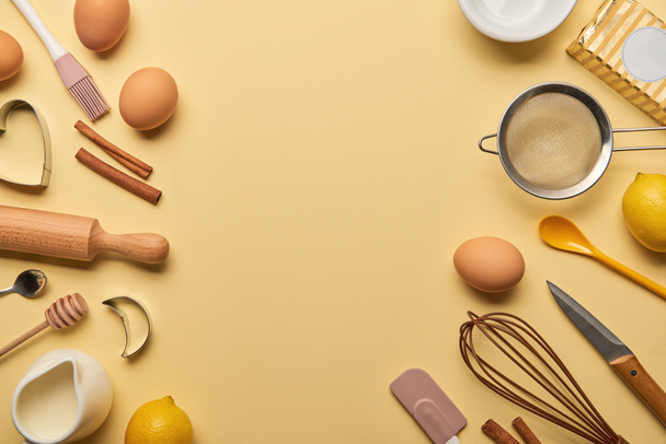 top view of bakery ingredients and kitchenware on yellow background - Foto, imagen