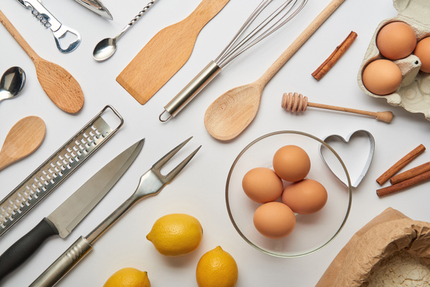 tendido plano con utensilios de cocina de metal y madera y productos crudos sobre fondo gris
  - Foto, Imagen